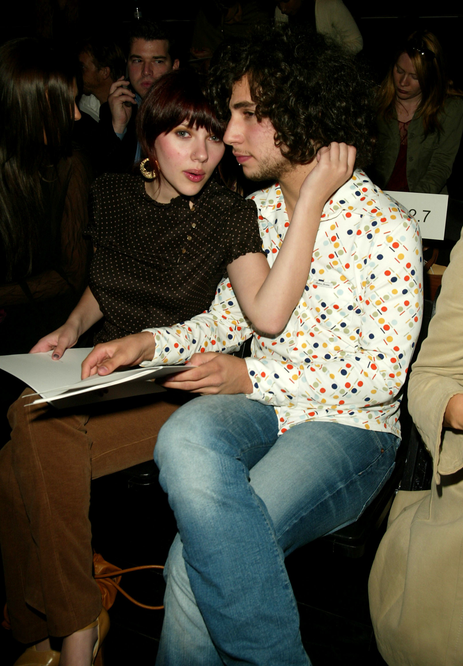 Scarlett and Jack seated together, she in a patterned top and corduroys and he in a printed shirt and jeans