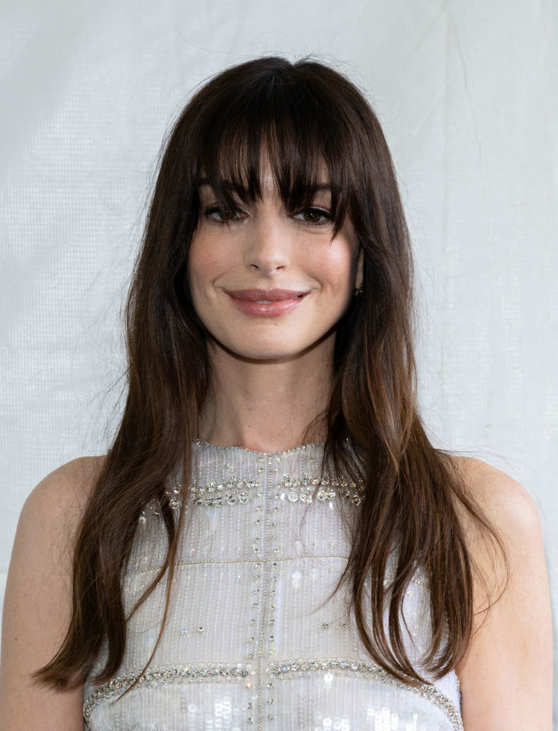 closeup of anne with bangs smiling, wearing a sleeveless beaded top