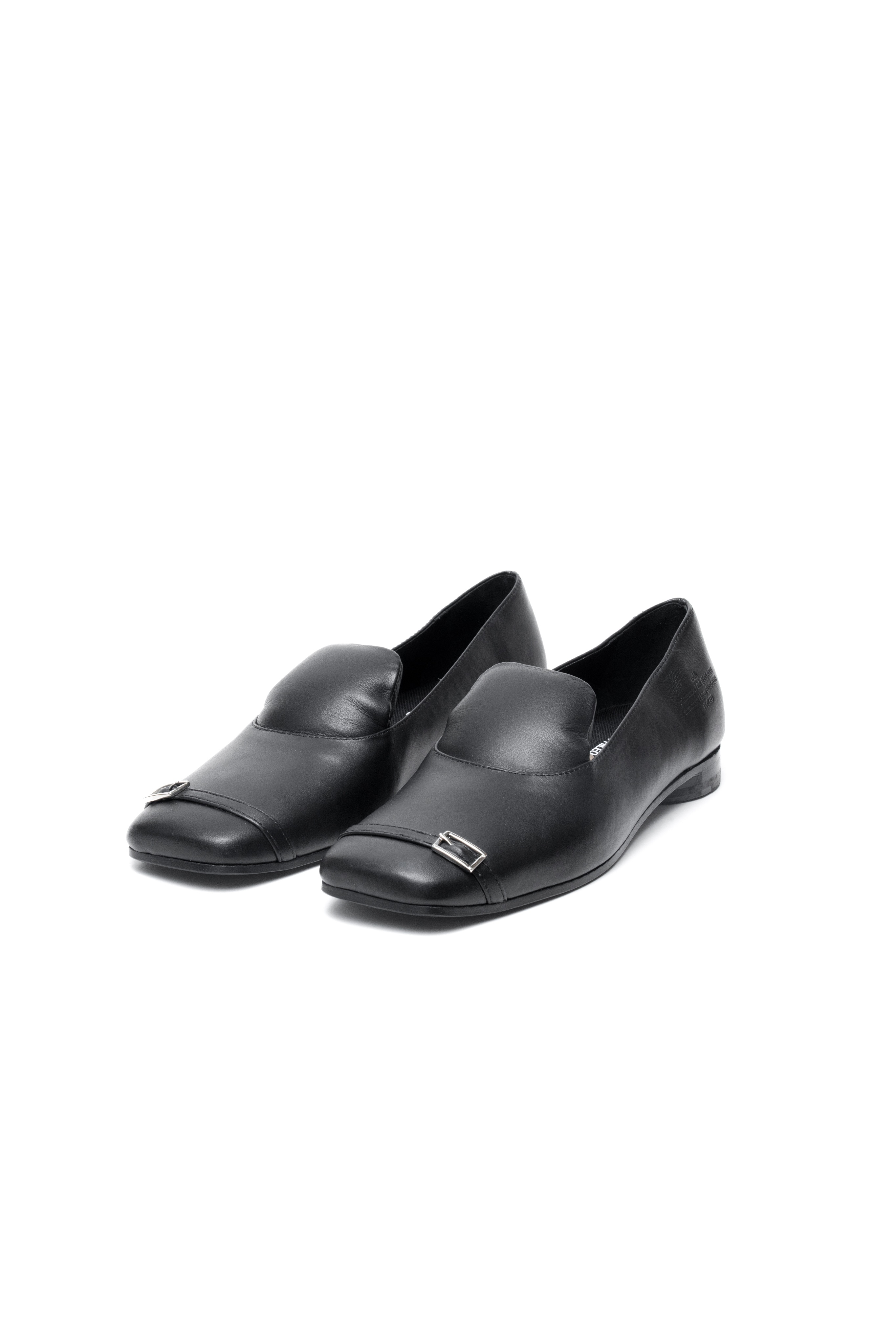 A pair of black leather loafers with a metal detail on a white background