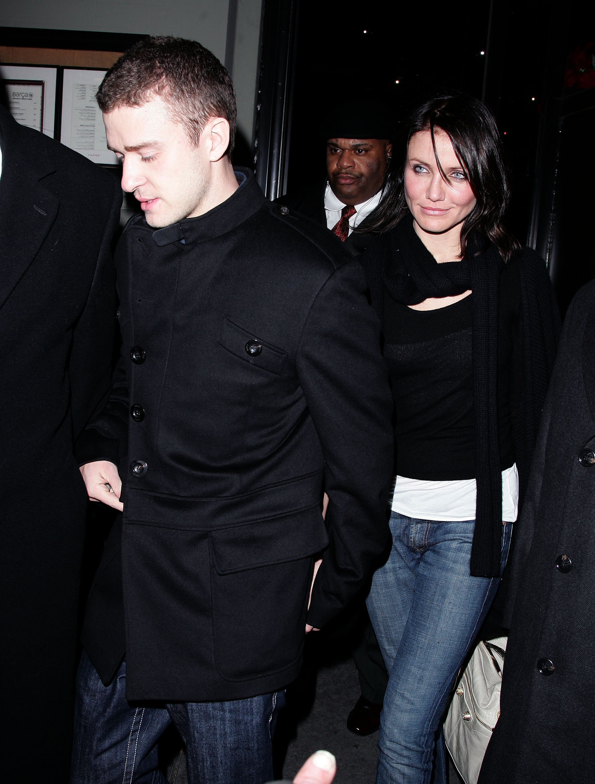 Justin and Cameron walking, he in a black coat and jeans and she in a dark jacket and jeans