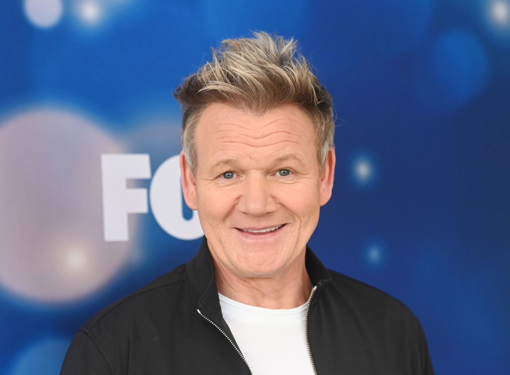 Gordon Ramsay smiling at a photo event, wearing a casual jacket and t-shirt
