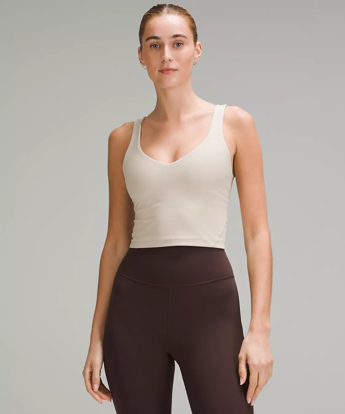 Model in white Align cropped tank top and brown leggings