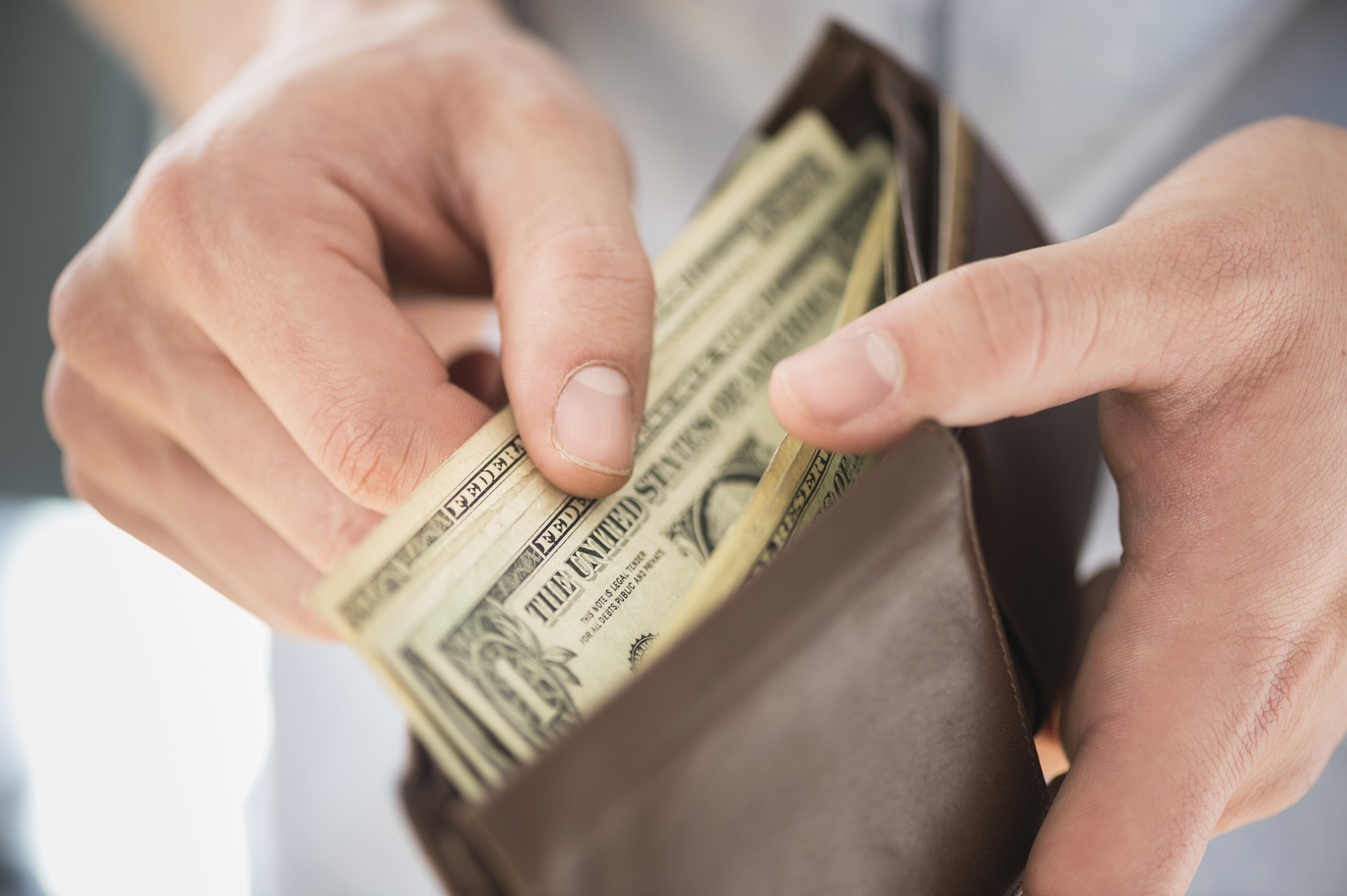 Person taking cash out of a wallet