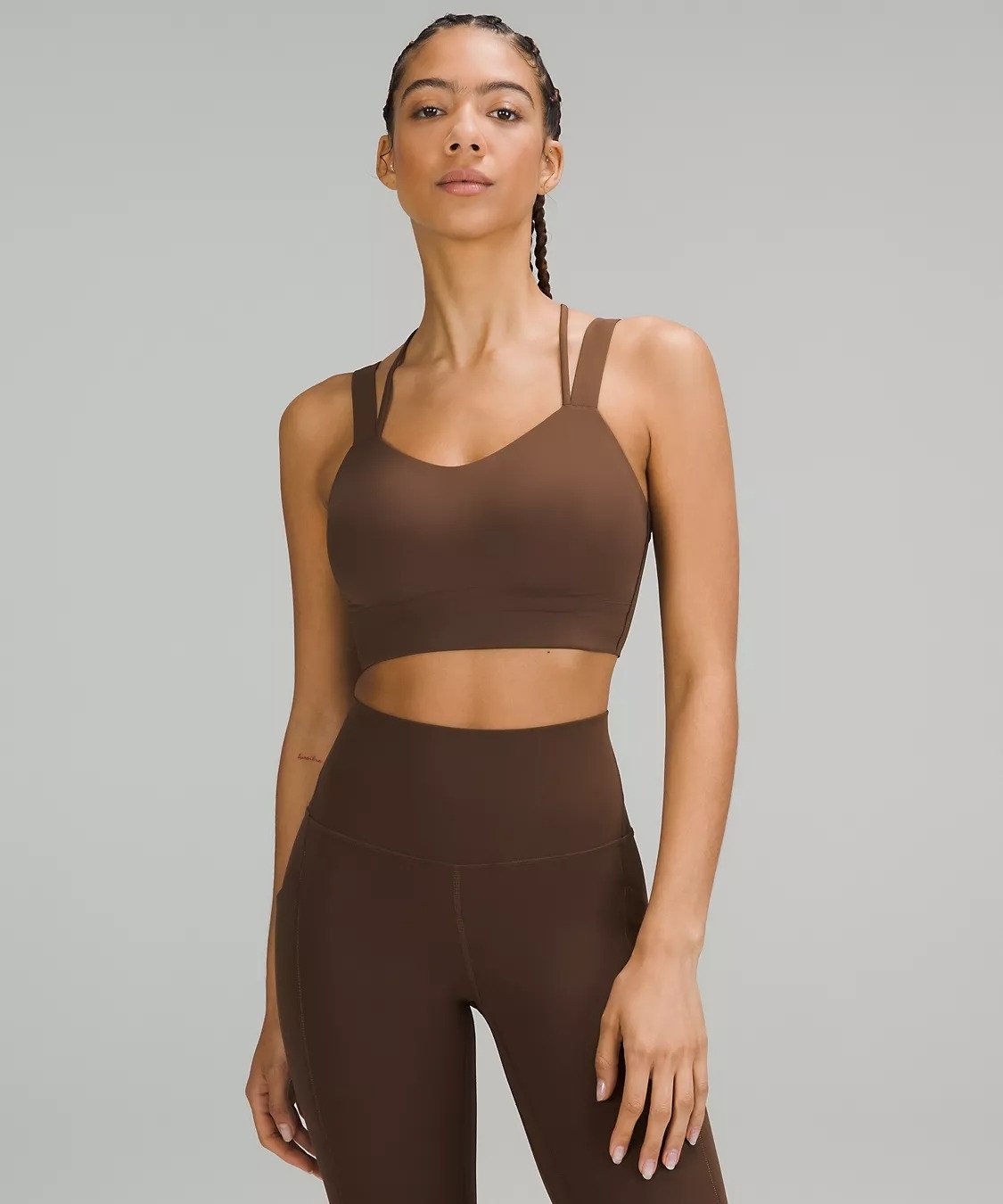 Model wearing a brown sweat-wicking sports bra and matching leggings