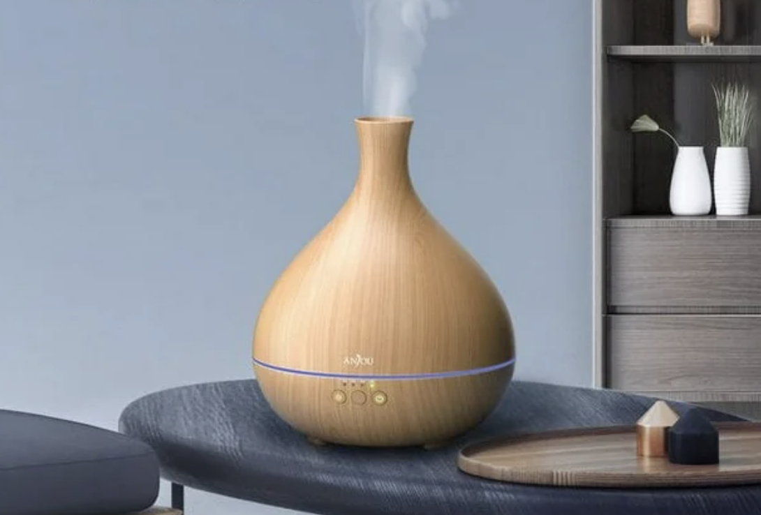 Wooden essential oil diffuser on table with subtle steam