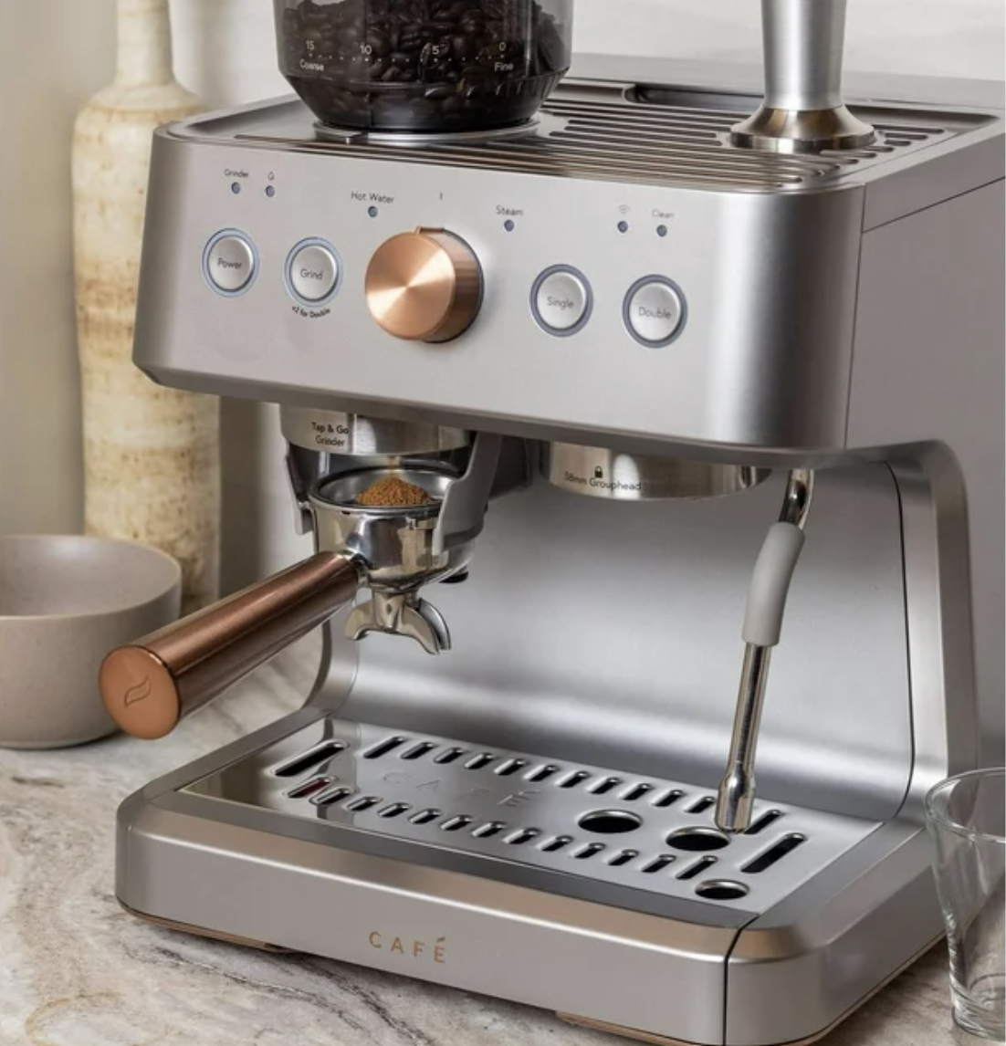 Espresso machine with coffee beans, cup, and metal finish on kitchen counter