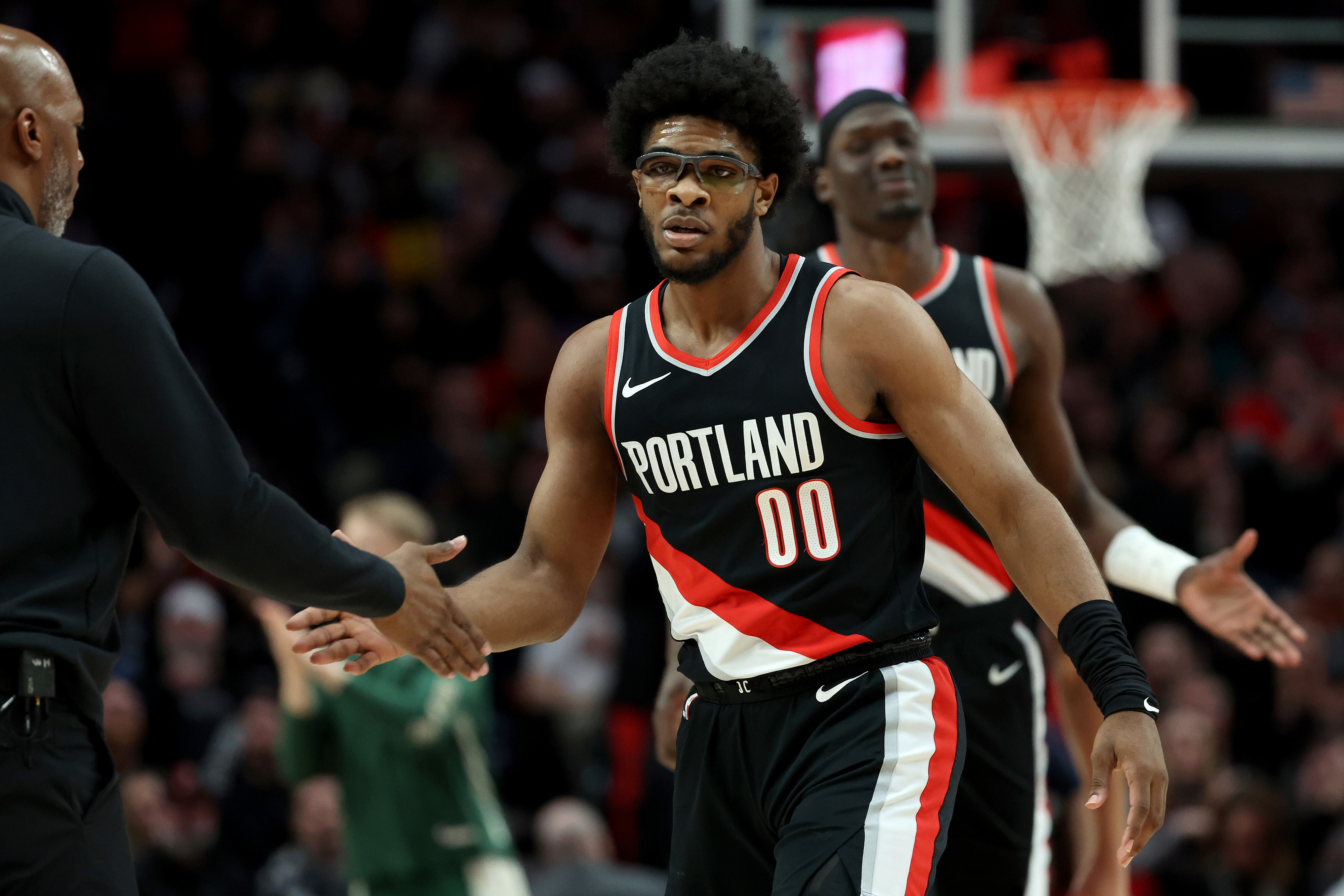 Basketball player in Portland Trail Blazers uniform high-fiving a teammate on the court