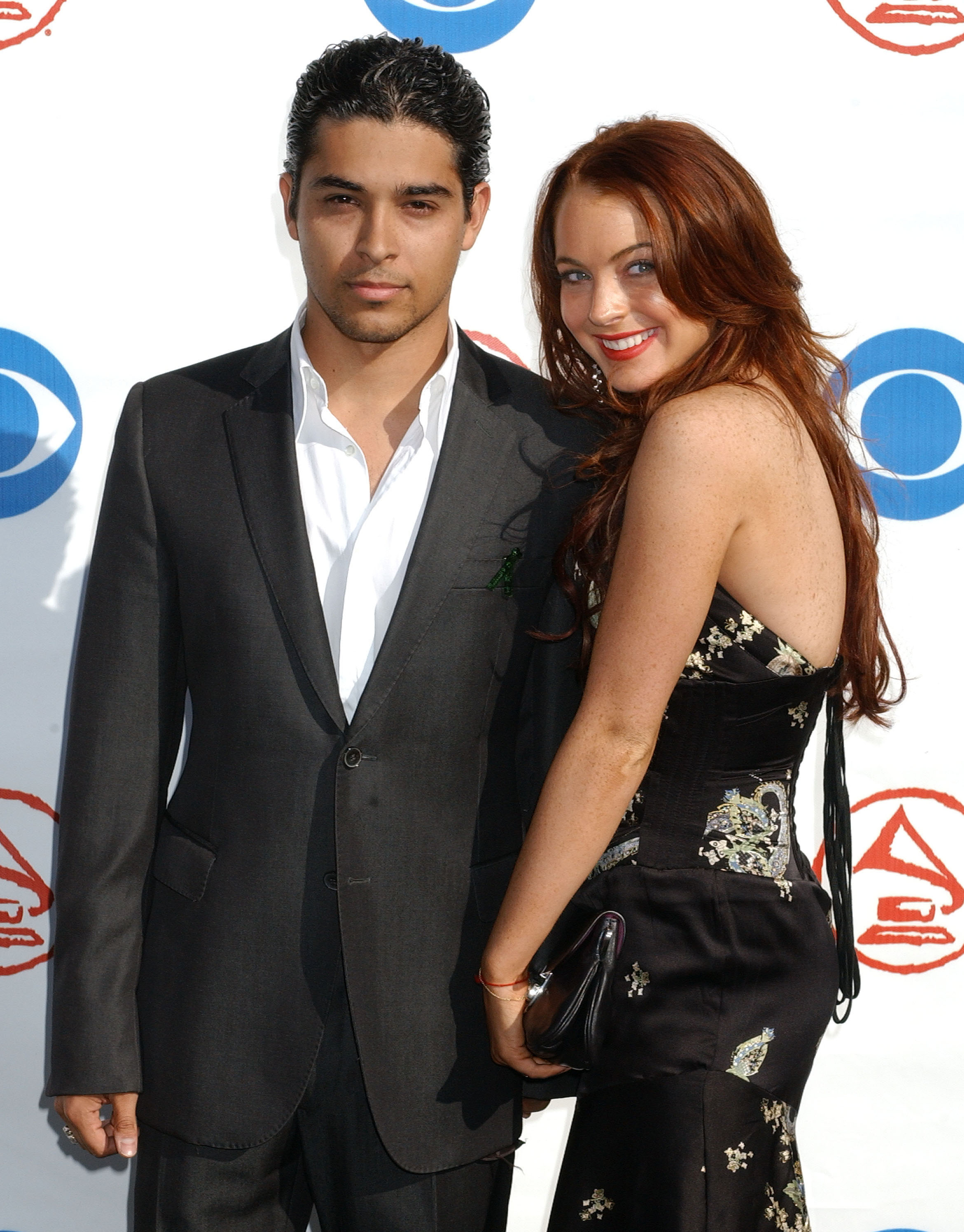Wilmer in a suit and Lindsay in an embroidered dress, posing together at an event
