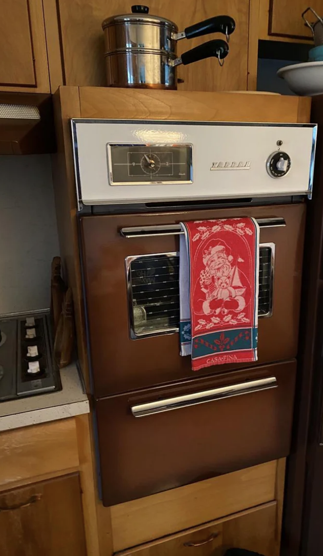 Vintage wall oven with a decorative towel hanging on the handle
