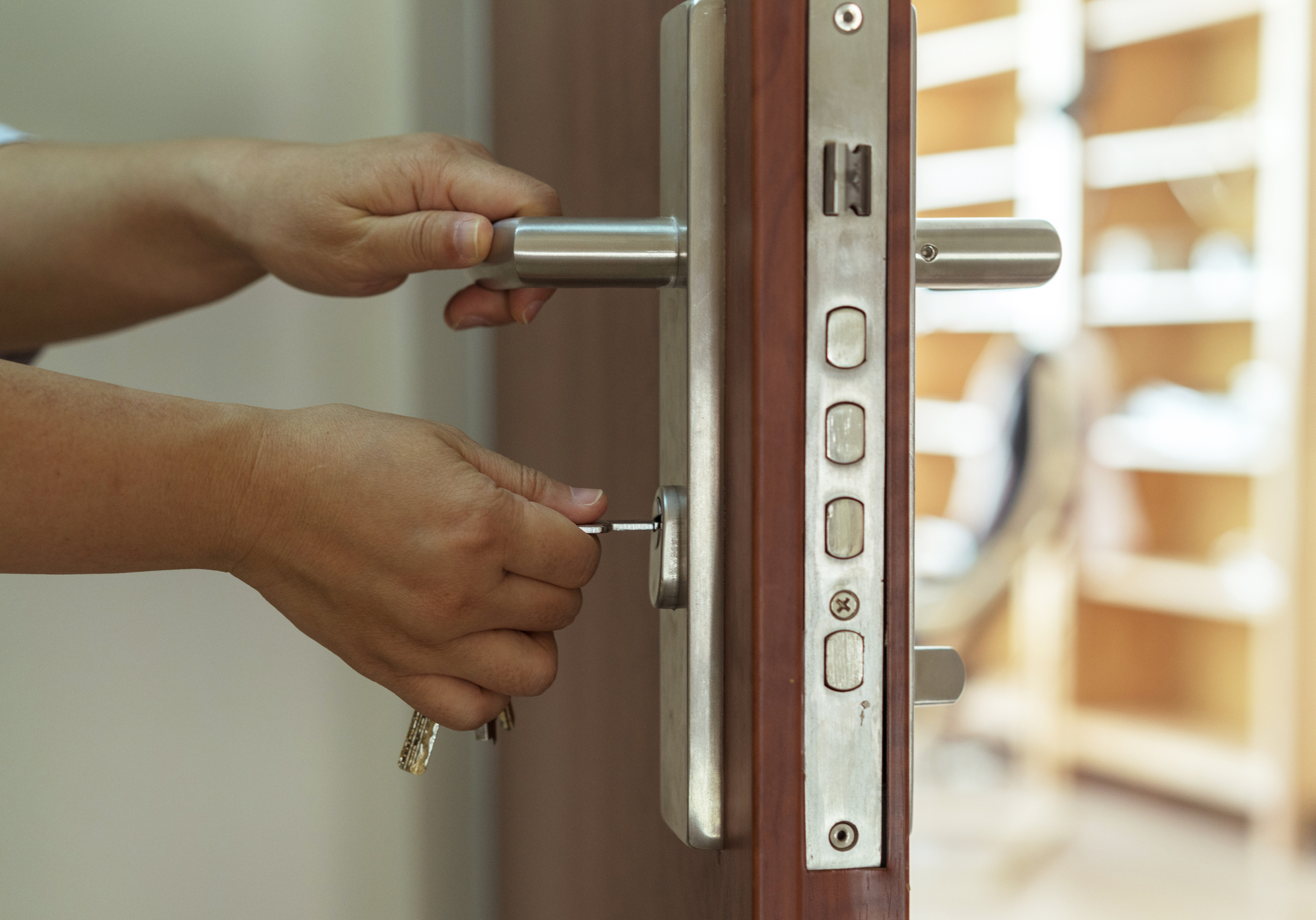 Person inserting a key into a door lock, preparing to unlock it