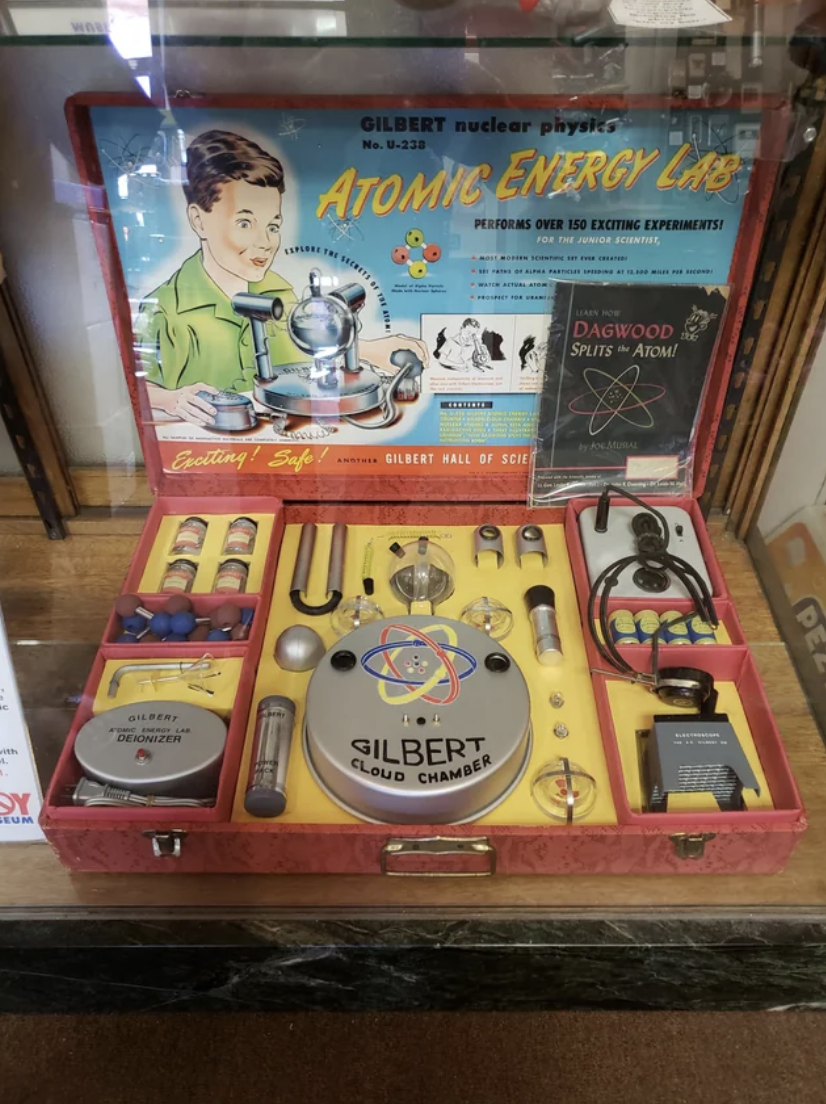 Vintage Gilbert Atomic Energy Lab kit with various scientific instruments displayed inside a case