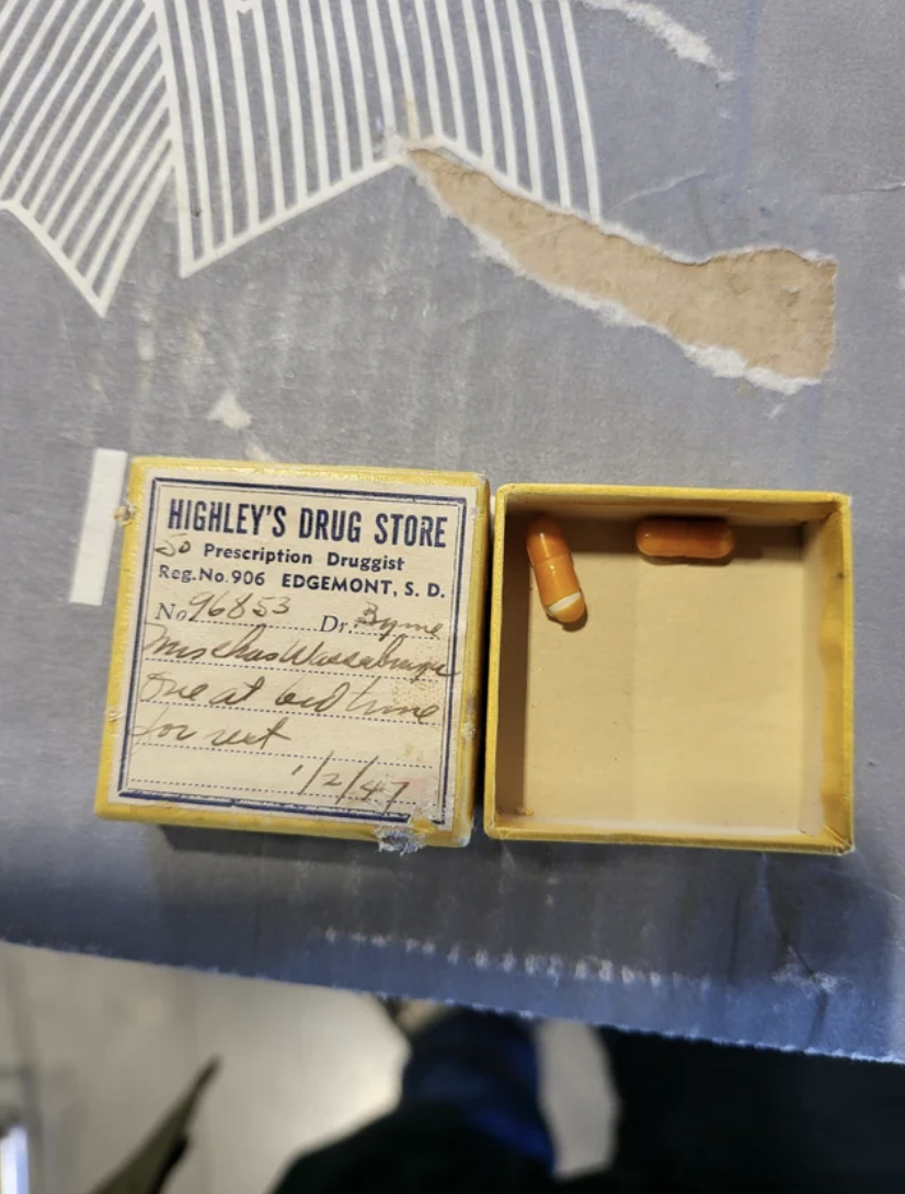 Old prescription box with a label from Higley&#x27;s Drug Store and capsules inside