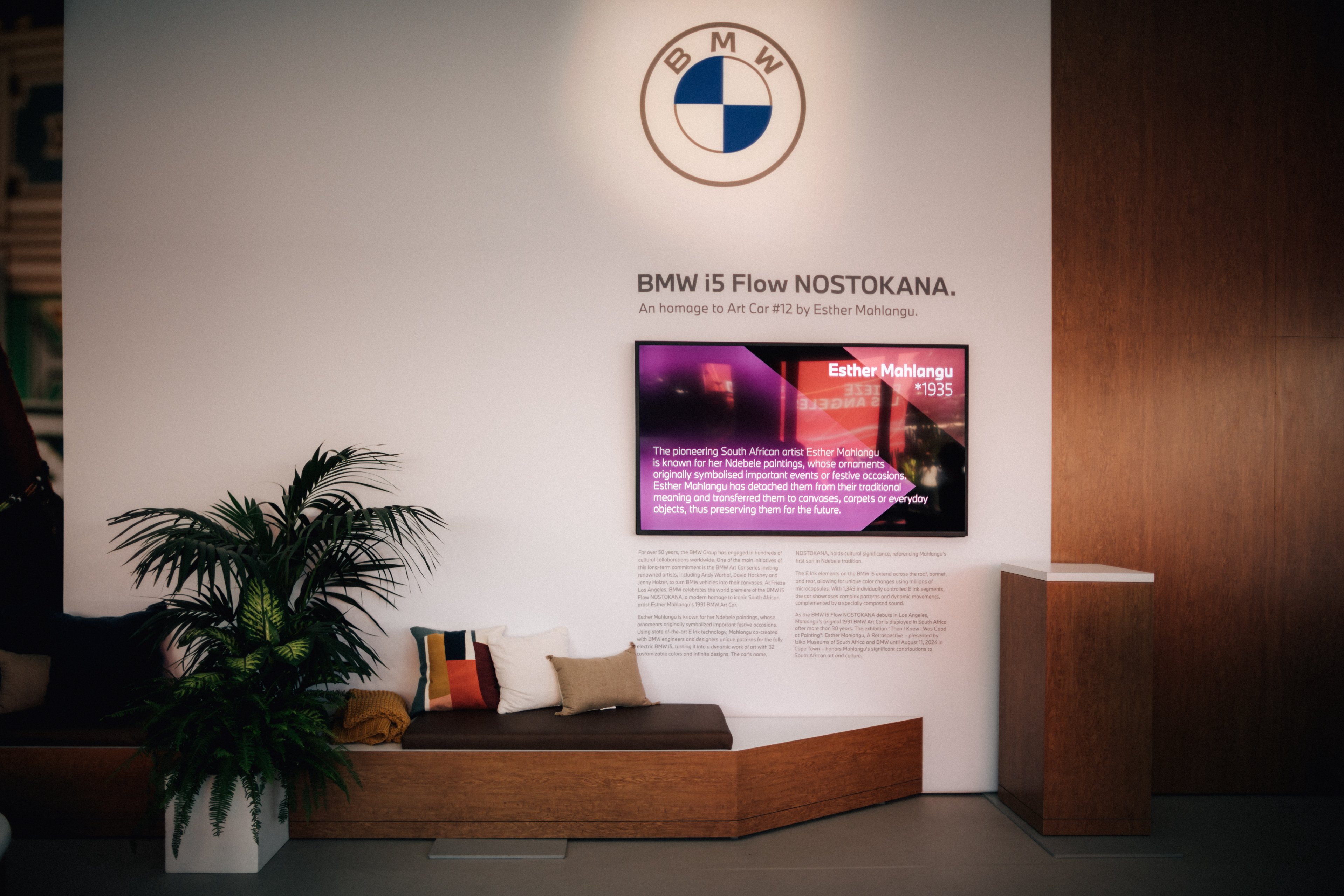BMW exhibition space with a promotional display for the BMW i5 Flow NOSTOKANA, including a monitor with Esther Mahlangu&#x27;s artwork