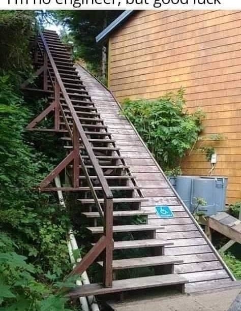 Steep wooden staircase outside with &#x27;good luck&#x27; message, appears unsafe