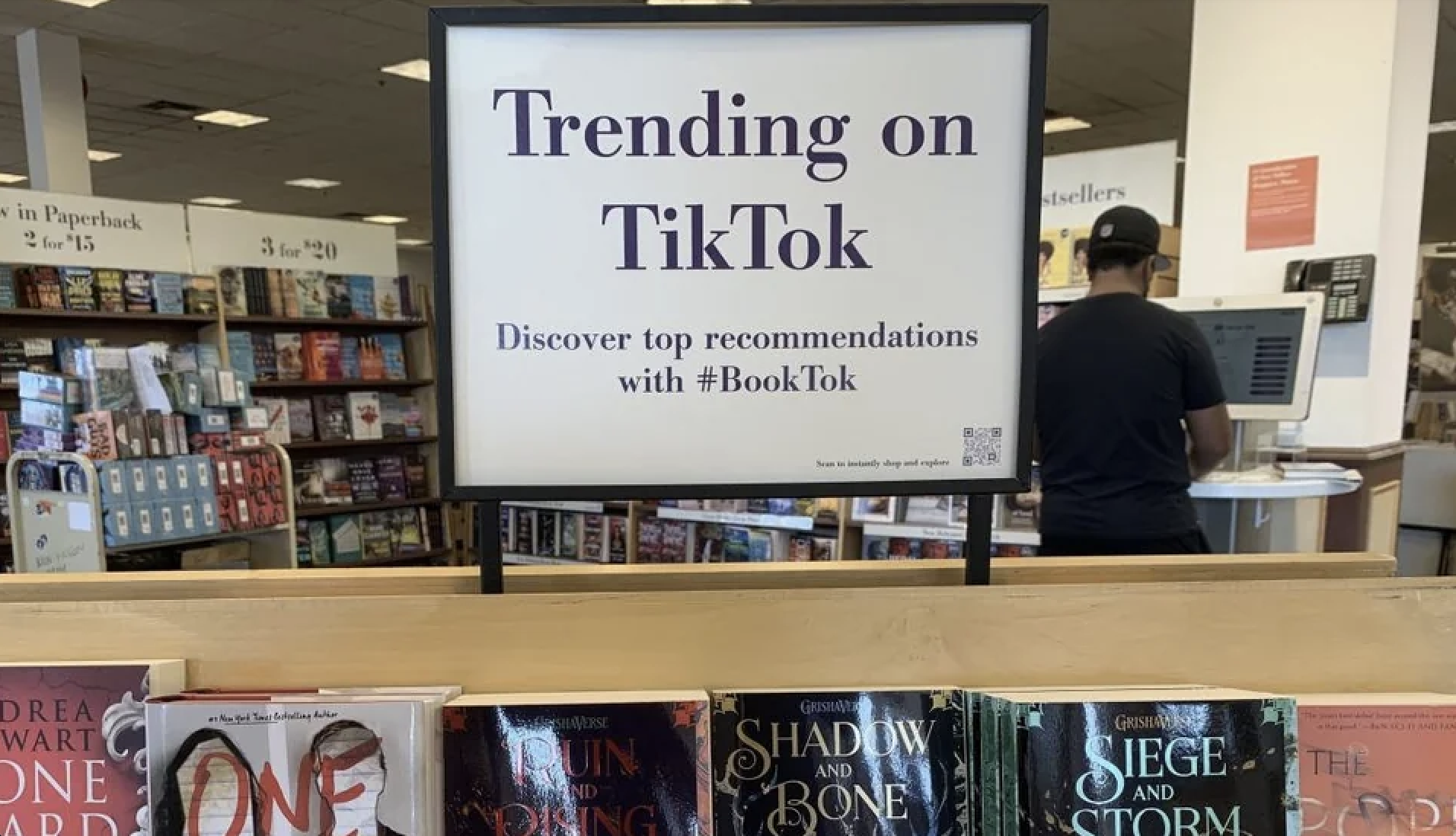 Sign reading &#x27;Trending on TikTok - Discover top recommendations with #BookTok&#x27; above a bookstore display