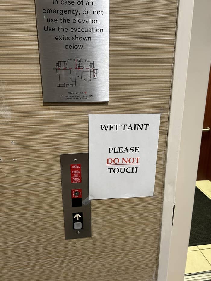 Sign next to an elevator reads &quot;PLEASE T&#x27; AINT DO NOT TOUCH&quot; with a diagram of evacuation routes above it