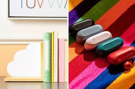 Assorted wireless earbuds showcased on a colorful striped background next to stylishly designed notebooks