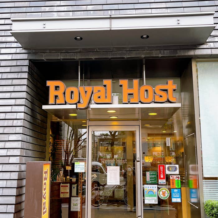 ロイヤルホストの店舗入口、様々なステッカーが窓に貼られている