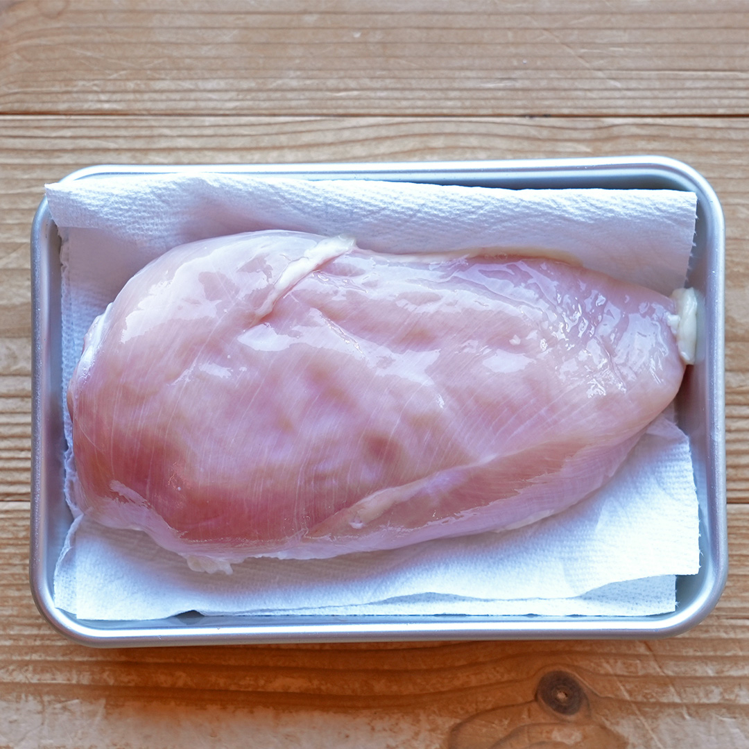 トレイにのせられた生の鶏むね肉。