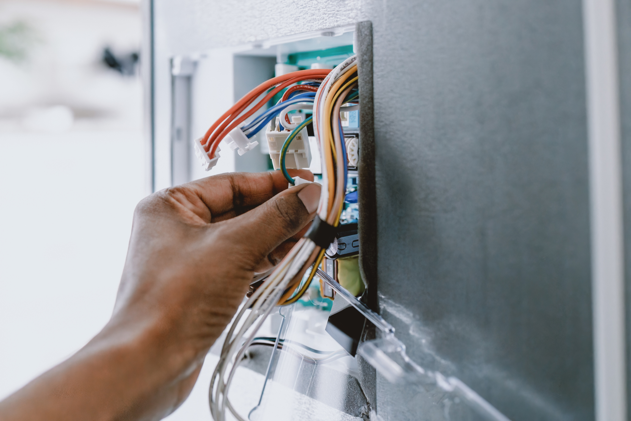 Hand adjusting wires on a thermostat installation