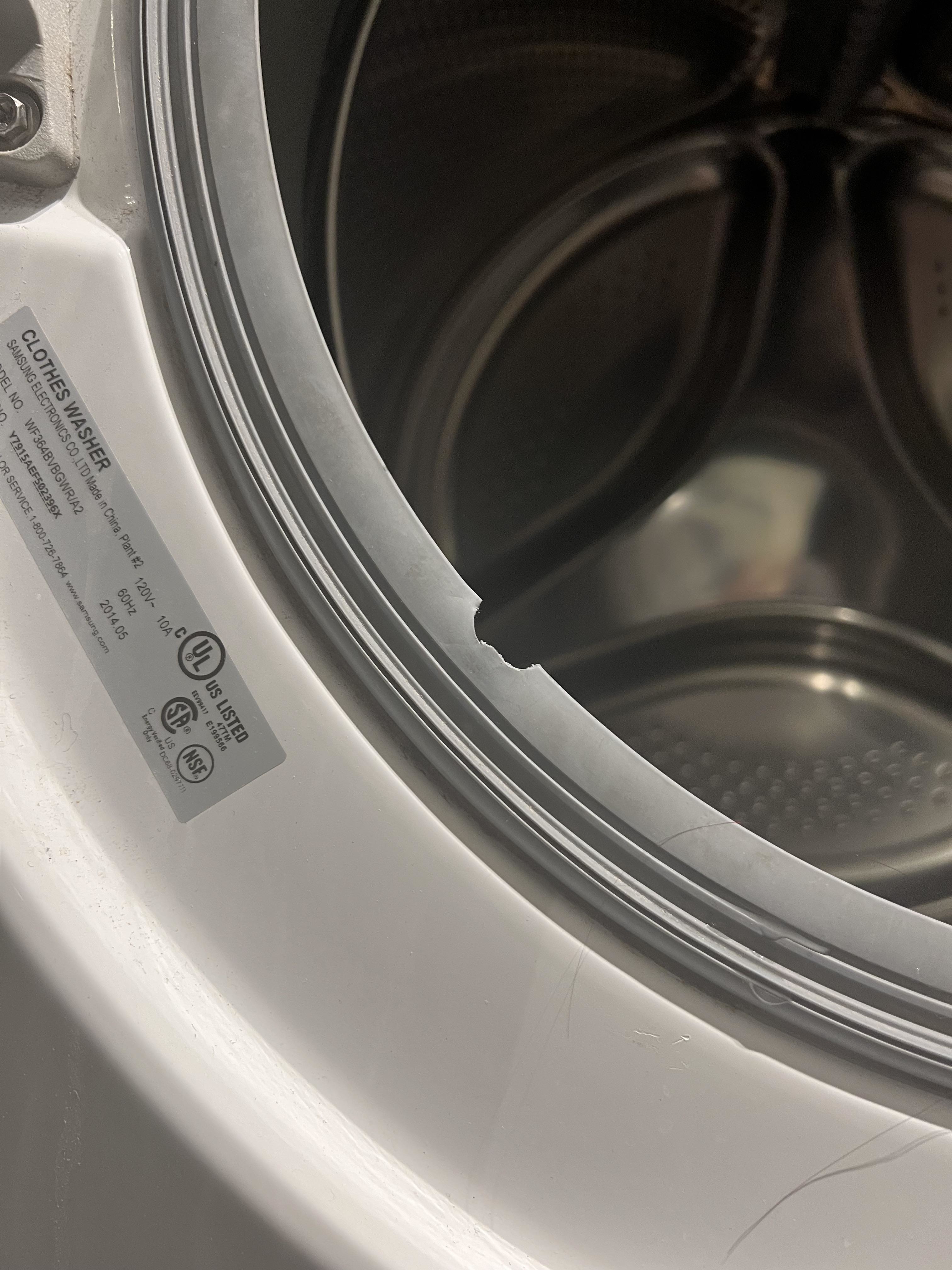 Close-up of a washing machine&#x27;s open door with a visible care label