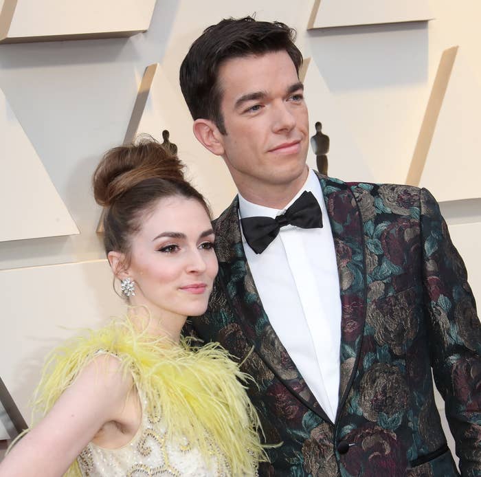 Anna Marie, wearing a feather-accented dress, poses for photos on the red carpet with John, who&#x27;s wearing a patterned jacket and bow tie