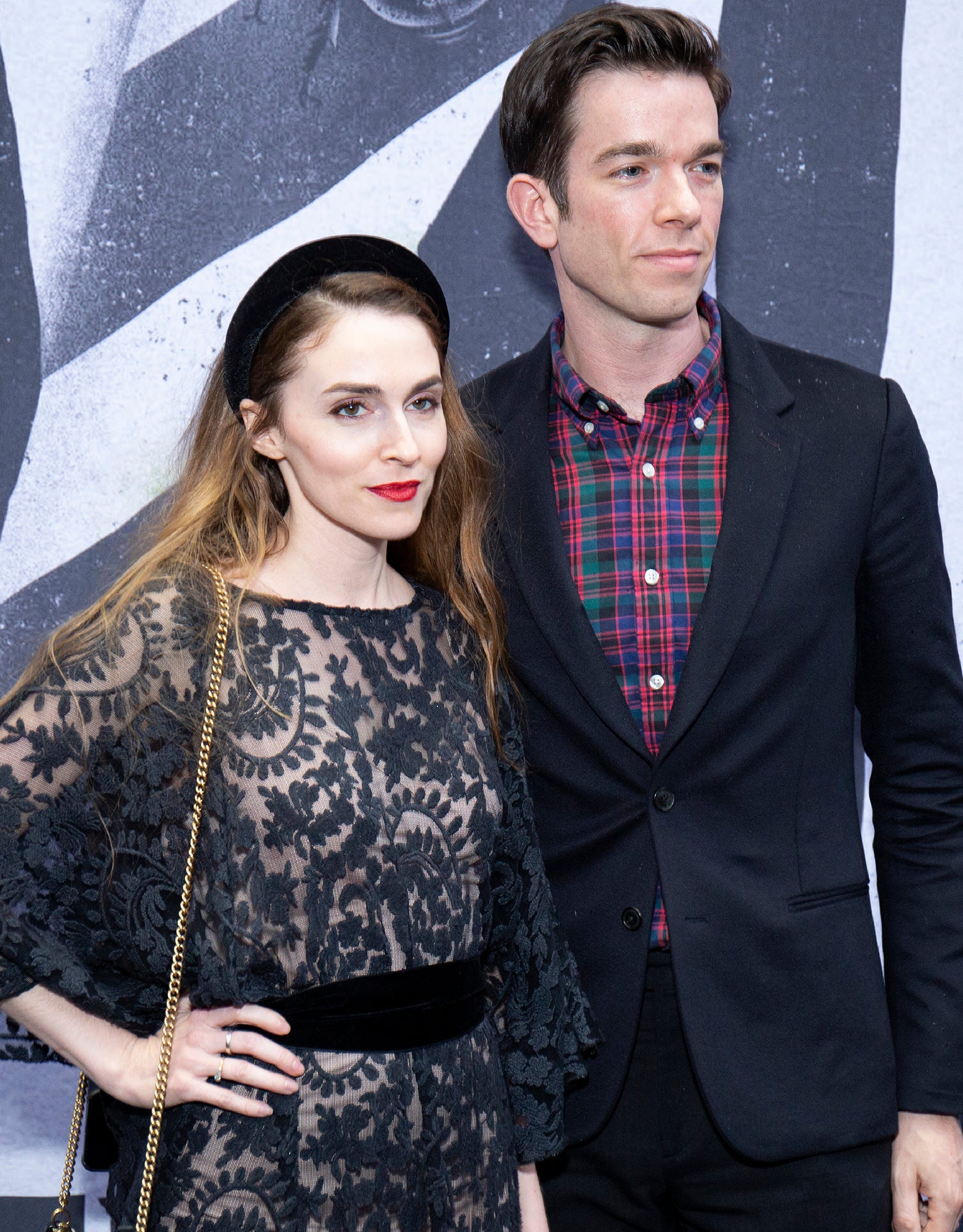 Anna Marie in a lace dress stands next to John who is wearing a plaid shirt and blazer at a formal event