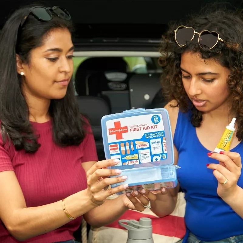Two women examining a first aid kit contents, suggesting practical shopping for safety essentials