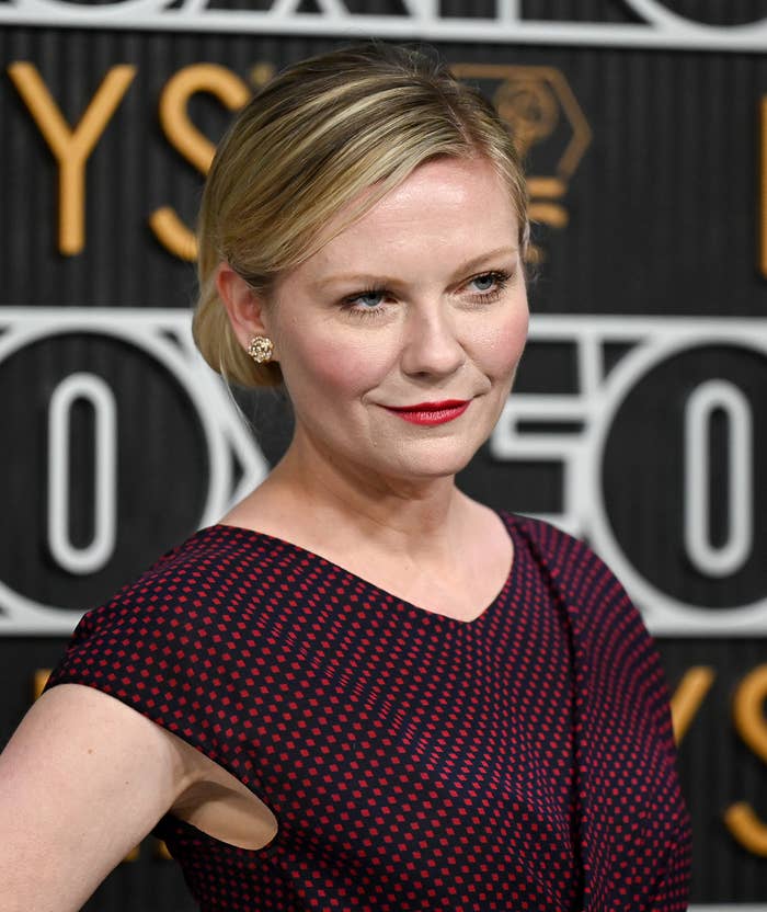 Kirsten Dunst in a dotted dress posing on the Emmys red carpet