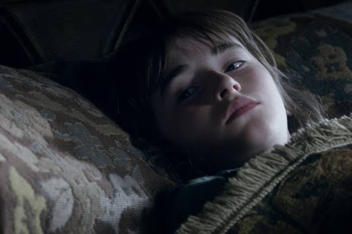 Bran Stark from Game of Thrones lying down, looking upwards with a solemn expression