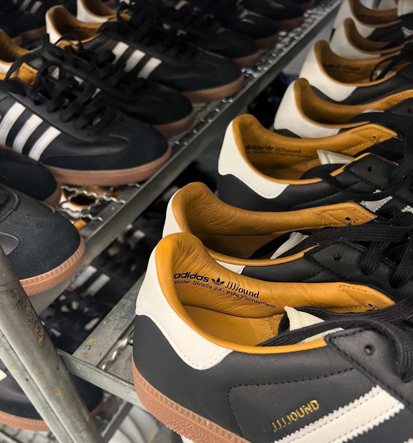 Close-up of Adidas Samba sneakers with distinctive black and tan design on a store shelf