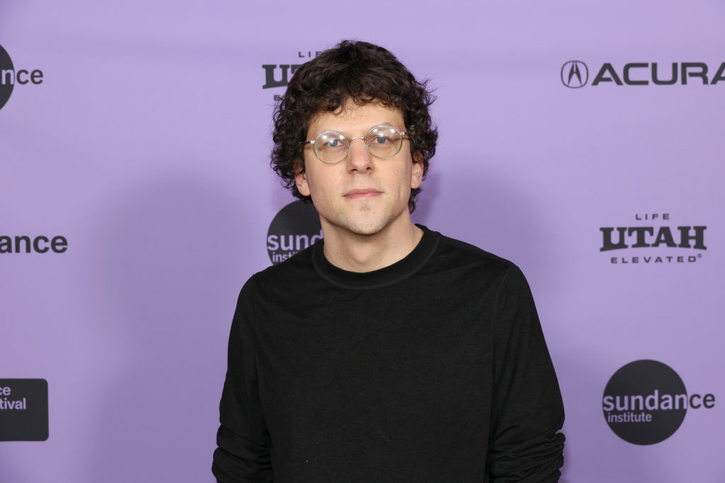 Jesse at Sundance event, backdrop with logos, wearing glasses