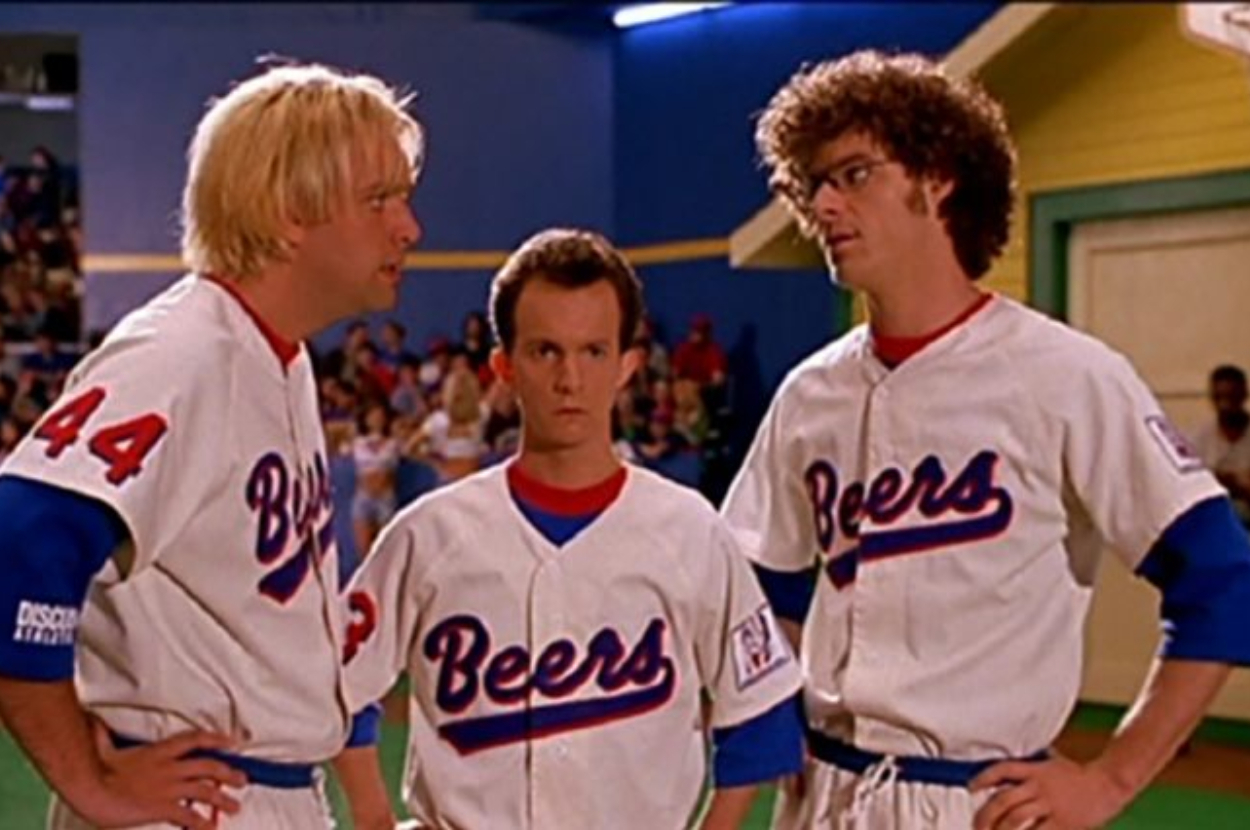 Three actors in &quot;BASEketball&quot; uniforms on a sports field look puzzled