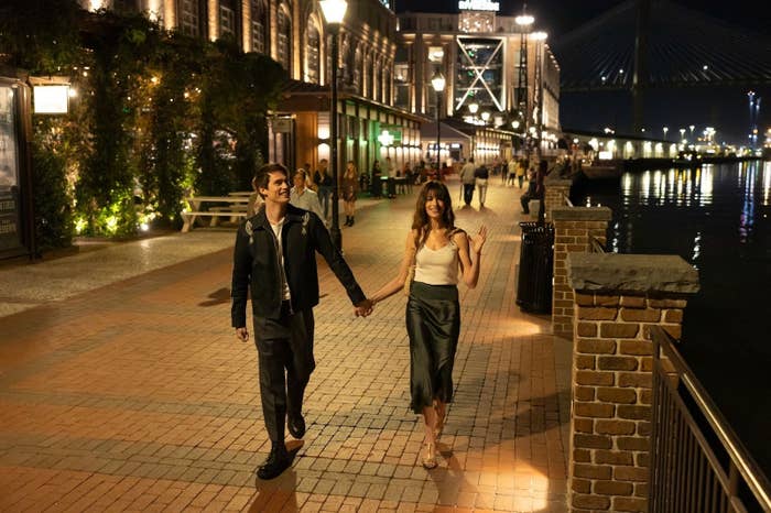 Anne and Nicholas walking hand in hand at night in a waterfront scene from the movie