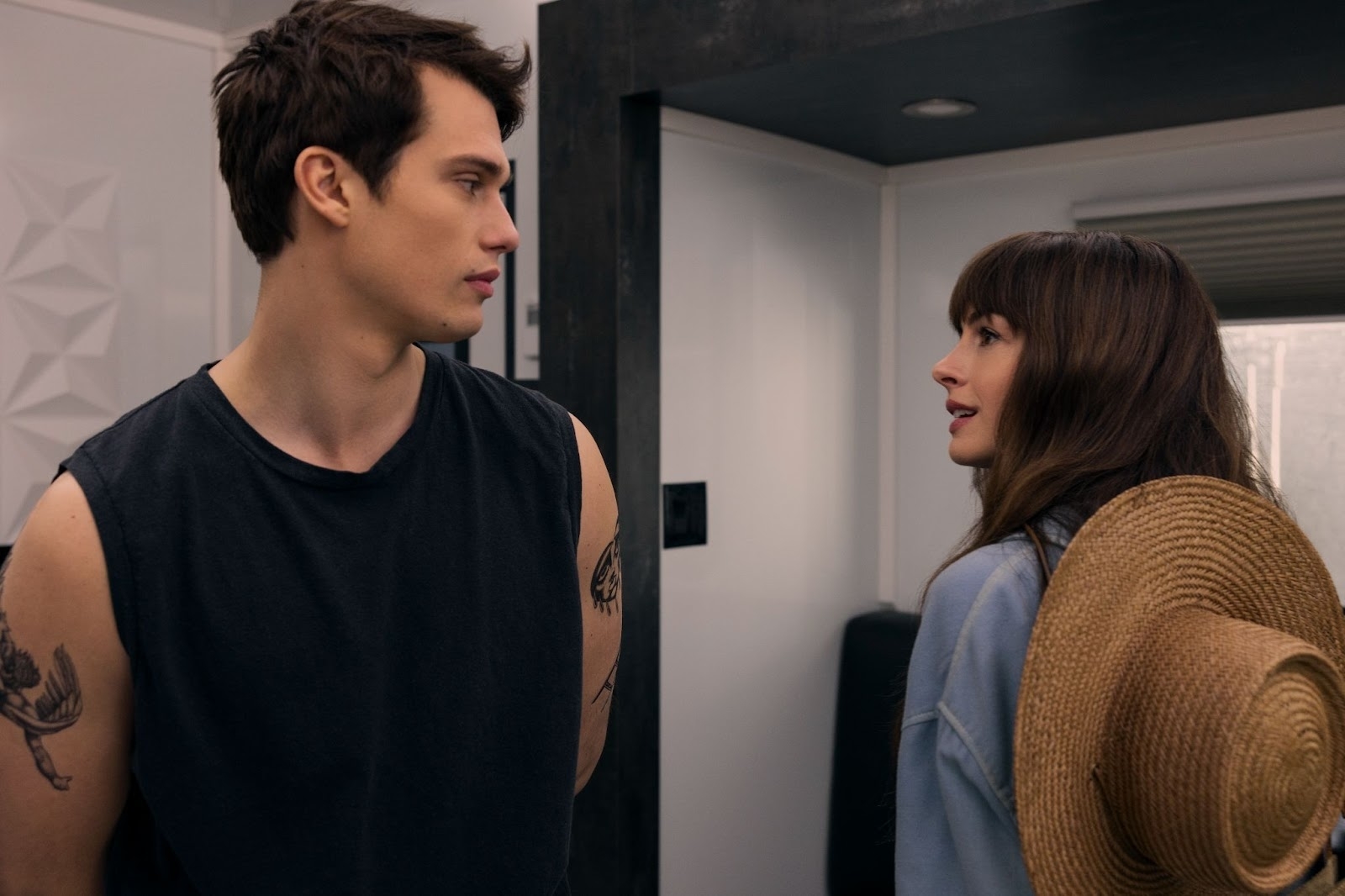 Solène and Hayes looking at each other as they stand in a room