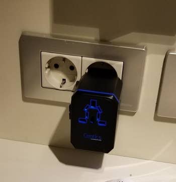 travel adapter plugged into an international outlet