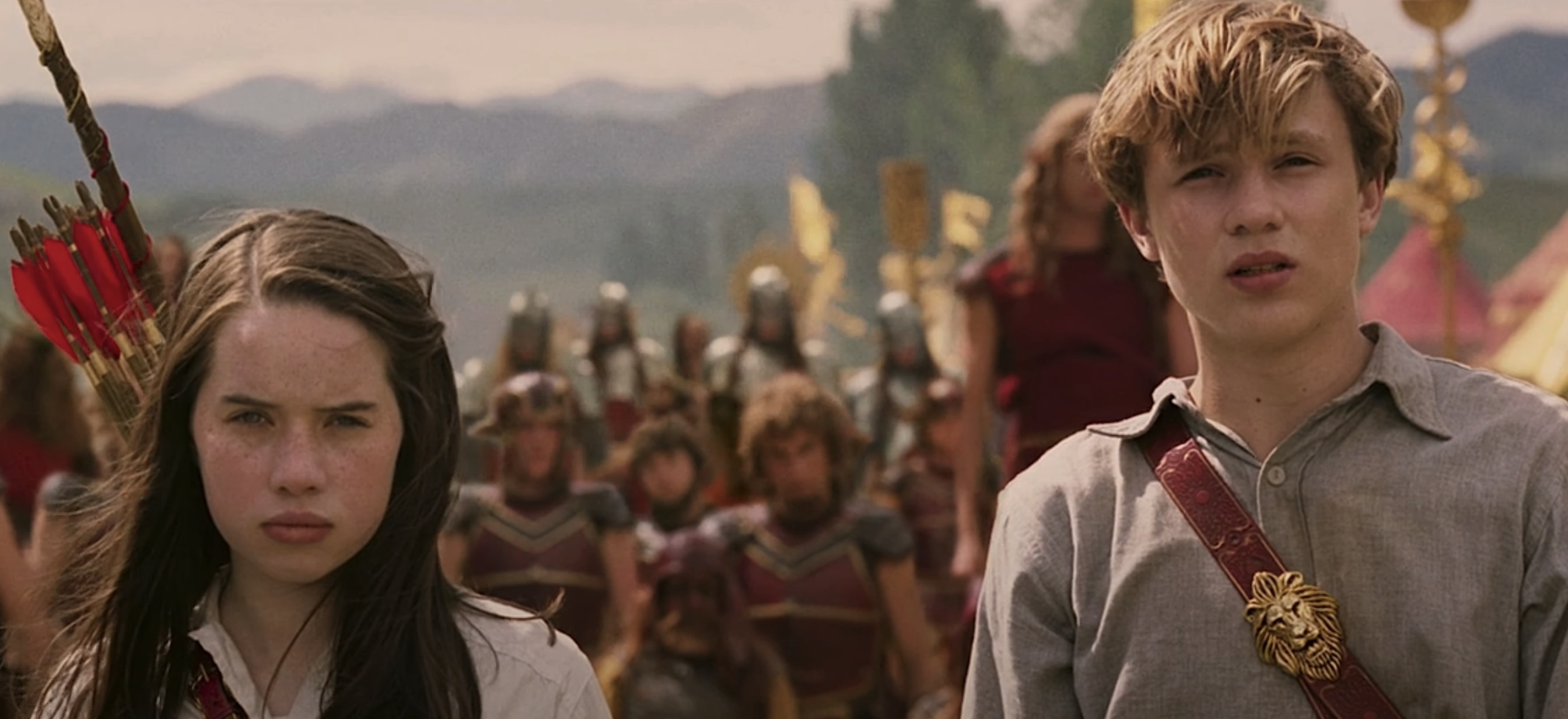 Susan and Peter from Chronicles of Narnia stand with solemn expressions, medieval army in background
