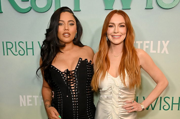 Ayesha Curry and Lindsay Lohan in elegant dresses posing together at an event