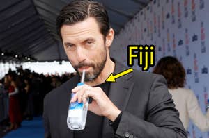 Milo Ventimiglia drinking Fiji water through a straw.