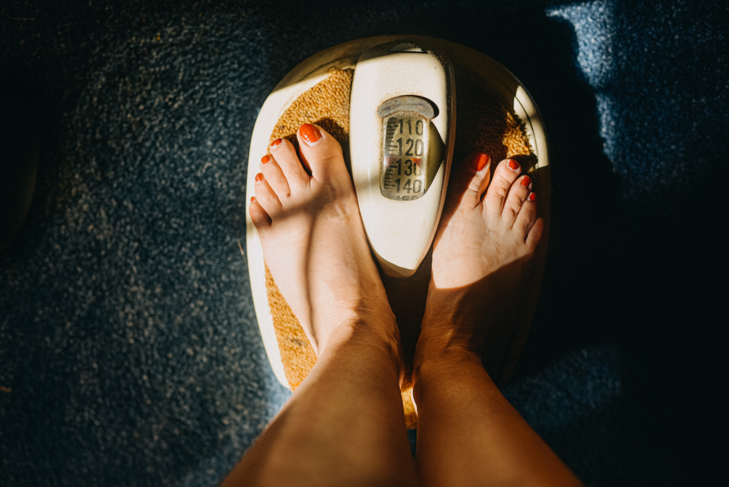 Close-up of a person&#x27;s feet on a mechanical bathroom scale