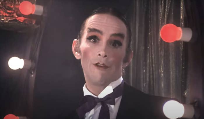 Person in stage makeup with a bow tie, performing