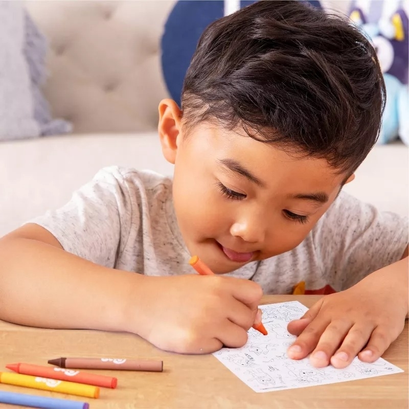 Child engaged in coloring activity with crayons; focus on creative play for shopping category