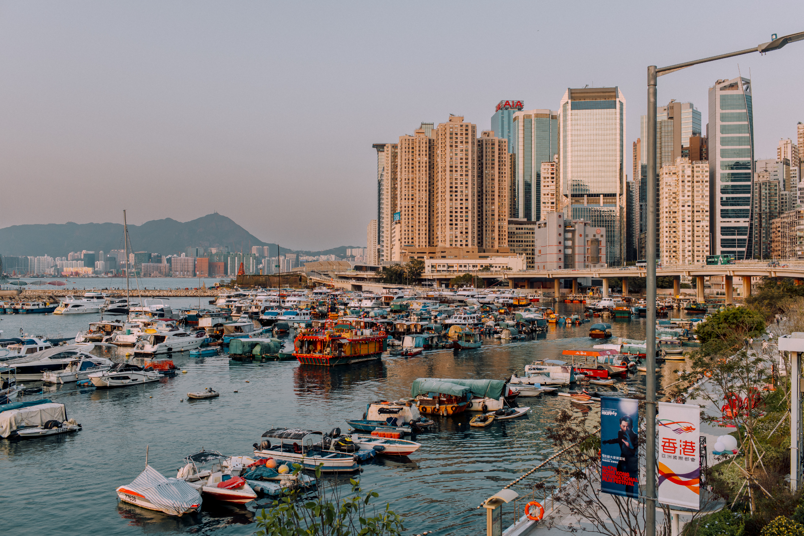 City skyline at dusk with boats in the foreground and high-rise buildings in the background