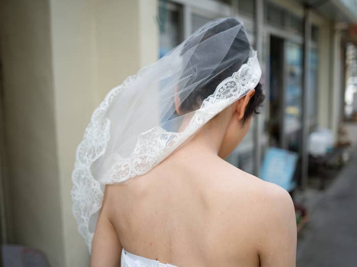 Woman in a bridal veil and dress, seen from behind
