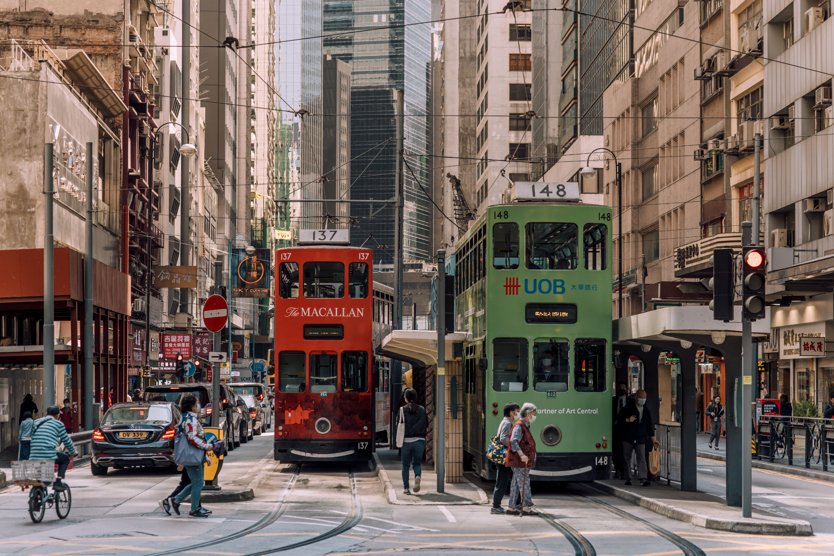 Two trams and pedestrians on a city street