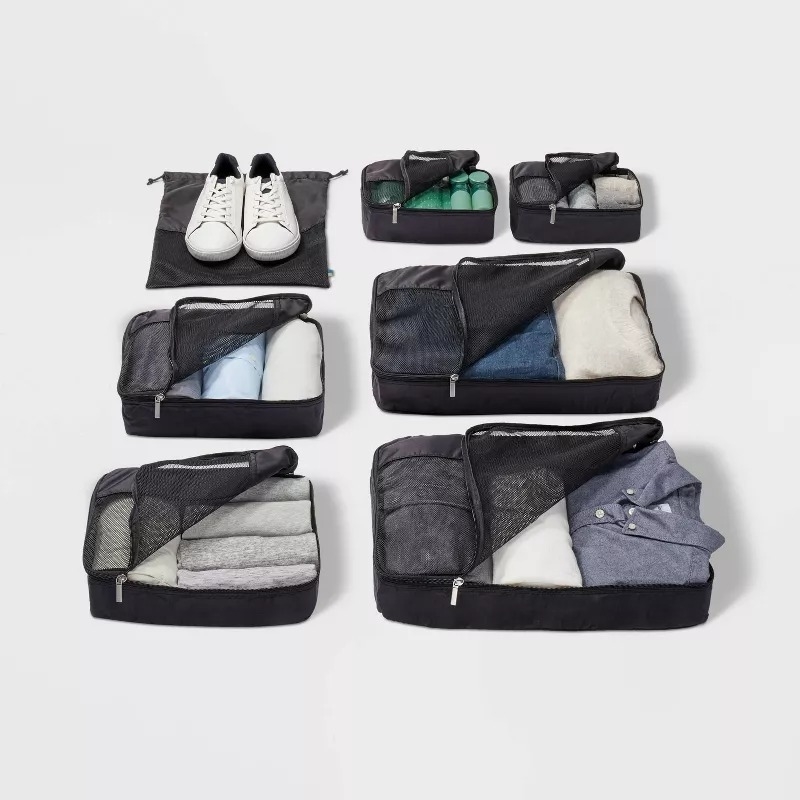 Assorted packing cubes with clothing and shoes arranged neatly for organized travel