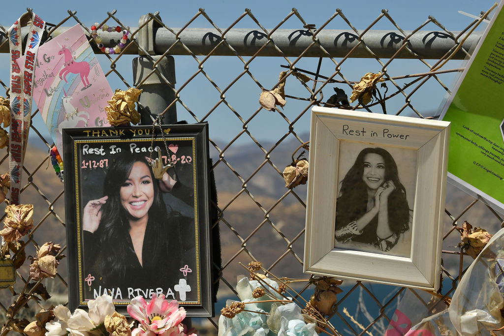 Memorial photos of Naya Rivera with flowers and messages on a fence