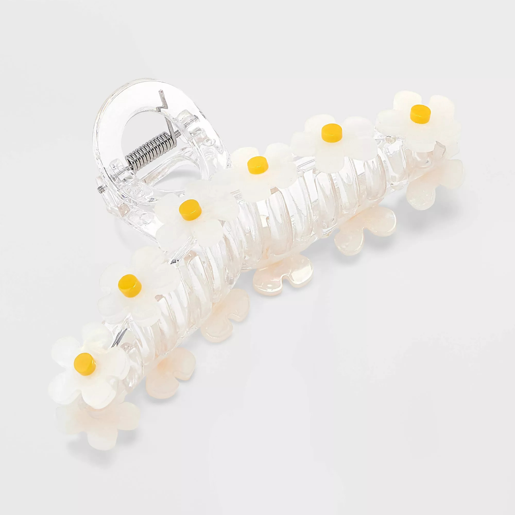Clear hair clip adorned with white daisy decorations and yellow centers