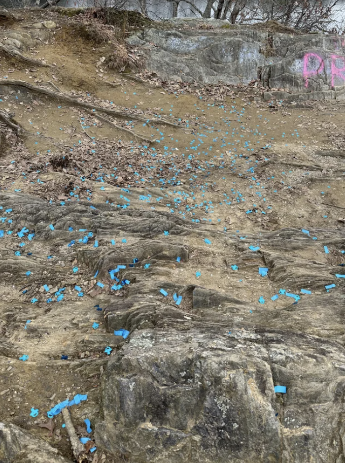 Rocky terrain scattered with numerous blue plastic pieces