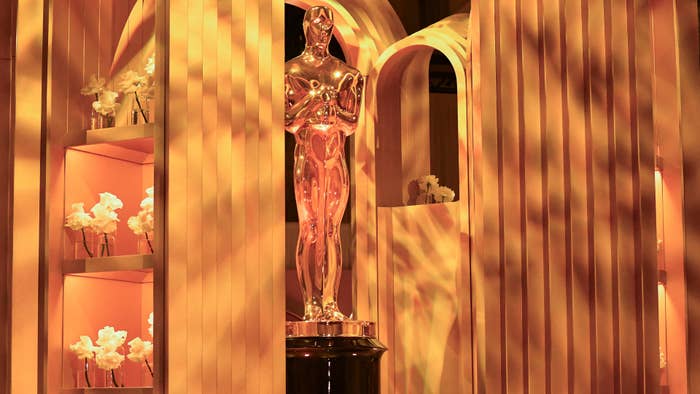 Oscar statue displayed among gold-toned decor with flowers, adding glitz to a pop culture event